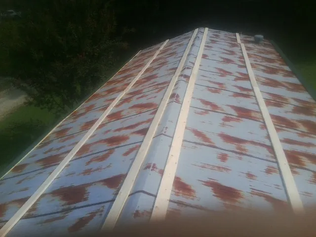 Rusted metal roof panels with new wood purlins before replacement — Storm Damage Roof Repair in Joseph by Roofing Brothers